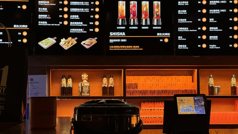 Bar with a wall of digital menu screens